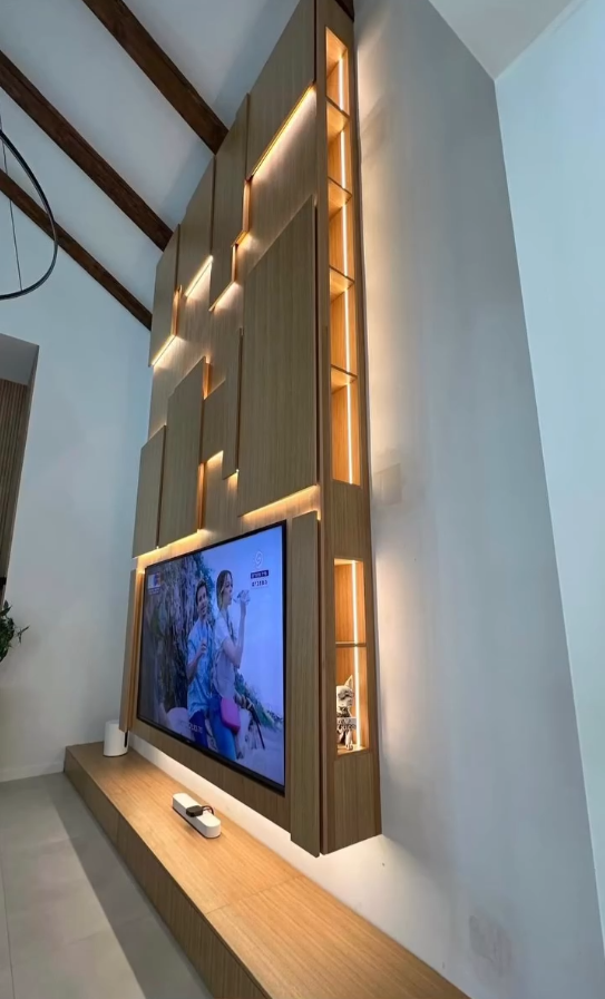 Minimalist living room design with wall-mounted television, oak floating shelf, and neutral color palette.