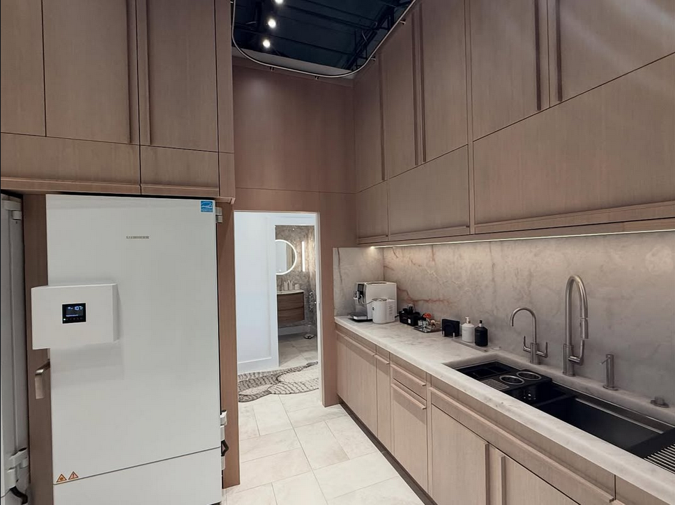 Integrated kitchen design featuring Liebherr refrigeration, custom wood cabinetry, marble backsplash, and under-cabinet LED lighting.