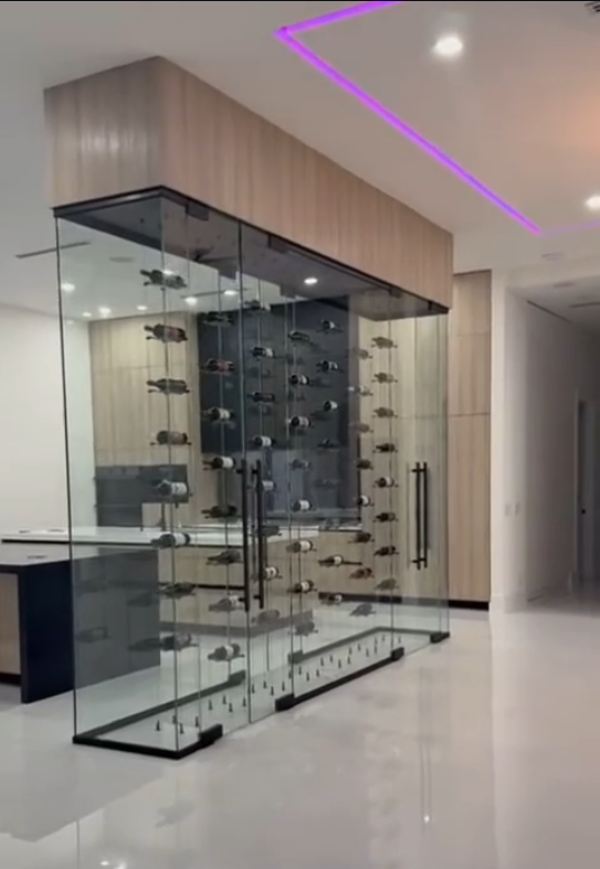 Luxury glass wine cellar design with minimalist hardware, floating wine racks, and contemporary interior lighting.