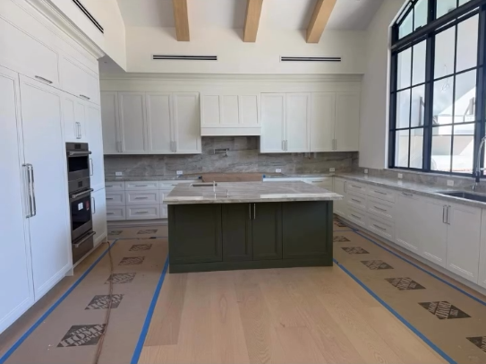 Luxury kitchen design with two-tone cabinetry, marble countertops, and industrial-style black windows.